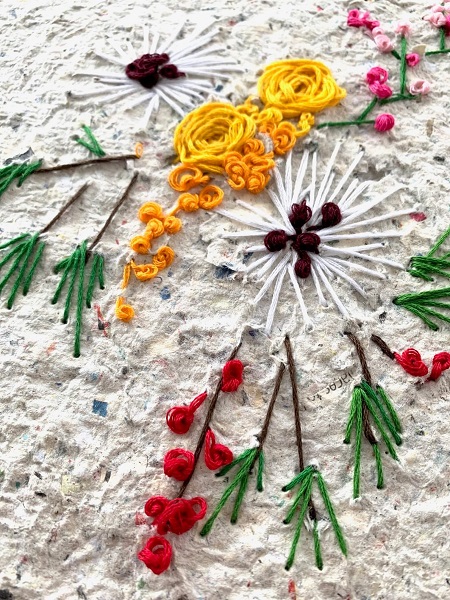 artwork of flowers and red berries embroidered on handmade paper