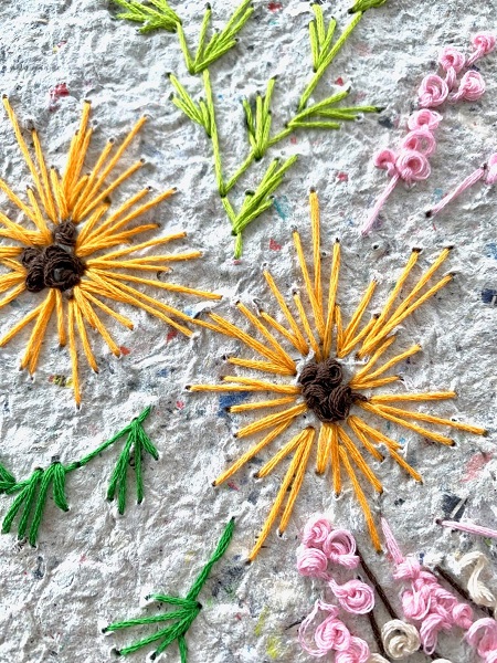 artwork of yellow and pink flowers embroidered on handmade paper