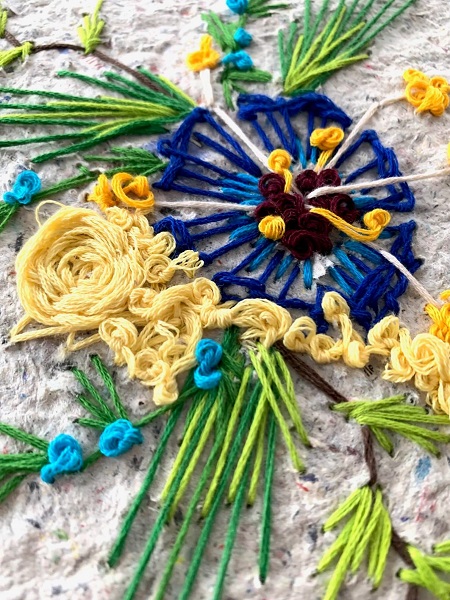 artwork of blue and yellow flowers created using embroidery on handmade paper