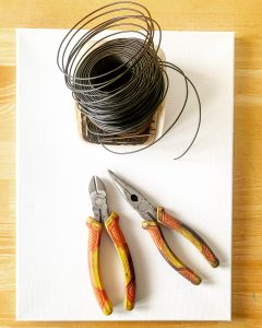 metal wire and pliers on a white art canvas